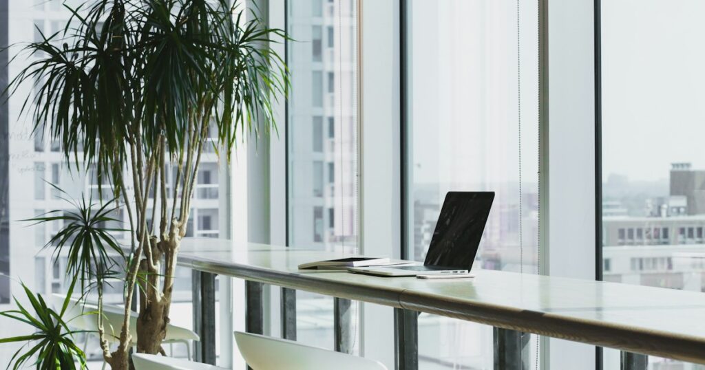 Dichtgeklapte laptop op een houten bureau in een leeg kantoor